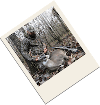 a man holding a deer in the woods